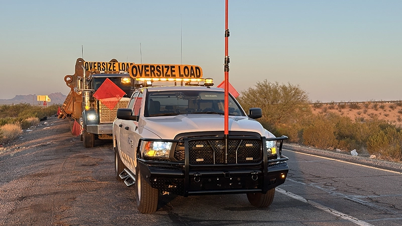 Arizona Pilot Car Service escort truck with caution lighting at sunset on a Phoenix heavy haul